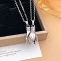 Silver magnetic couple necklaces with hand-holding pendants in a beige jewelry gift box - Hand in Hand Style (XL1938) / Silver