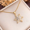 Golden snowflake necklace with zircons and pearls displayed on a beige velvet jewelry box - Rotatable Snowflake (XL986) / Gold