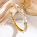 Gold-plated floral bangle with white enamel inlay and sparkling crystals on silk background - Gold White