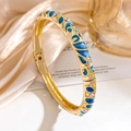 Elegant gold-plated bangle featuring blue enamel wave patterns and white rhinestones - Gold Blue