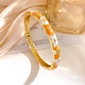 Chinese style open bangle in gold finish with orange enamel and white floral patterns - Orange