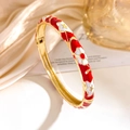 Golden open bangle with red and white enamel floral and star patterns in retro style - Red