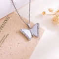 Zilveren vlinderketting met witte schelpinleg en zirkonia-accenten aan een kruisketting - Vlinder Ketting(XL1094) / Zilver