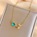Golden tulip necklace featuring a blue drop gemstone pendant with sparkling zircon leaves - Blue Tulip Necklace Gold