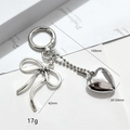 Detailed view of silver bow and heart keychain showing size and metal texture - Antique Silver Bowknot Heart Pendant Style (银色桃心古银蝴蝶结款)