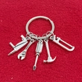Set portachiavi 5 pezzi in metallo argentato con martello e chiave su sfondo rosso - Set Pialla Chiave Cacciavite (2#)