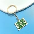 Detail of a golden soccer field keychain with green enamel surface and polished metal frame - Green Soccer Field Pendant (9#)