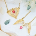 Golden angel wing necklace featuring a red pear-shaped gemstone and shimmering rhinestones - Soaring Wings (XL678) / Gold