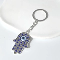 Porte-clés Main de Fatima argenté avec strass bleus et perle œil protecteur bleu - Anneau De Clé Main De Fatima Strass Bleu