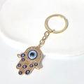 Porte-clés Main de Fatma doré avec breloques œil bleu et cristaux brillants en strass - Anneau De Clé Main De Fatima Dorée