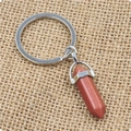 Détail d'un porte-clés avec pendentif hexagonal en pierre de sable dorée brune et anneau - Grès doré