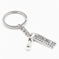 Silver fitness dumbbell keychain with Strong Is Beautiful tag on white background - Strong Is Beautiful Style