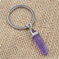 Vue détaillée d'un porte-clés pilier en cristal violet sur fond de toile de jute - Améthyste