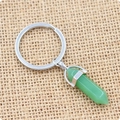 Porte-clés cristal hexagonal vert avec anneau argenté sur fond de toile de lin - Aventurine Verte