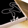 Silberne LOVE Herz-Halskette mit funkelnden Zirkonia-Anhängern auf einer Schmuckschatulle - LOve (XL2335) / Silber