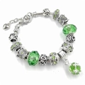 Detalle de cuentas de cristal verde esmeralda y pulsera de serpiente con corazón - Verde