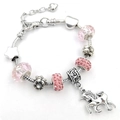 Detalle de pulsera plateada con cuentas de cristal rosa y colgante de unicornio - 14cm / Rosa