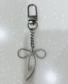 Silver metal bowknot keychain with lobster clasp on a textured stone surface - Small Bowknot Door Buckle 2