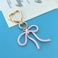 Light pink bow keychain with a golden heart-shaped clasp on a sky blue background - Pink Bowknot KC Gold Heart Buckle