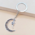 Close-up of vintage silver fairy pendant with hollowed moon charm on metal keychain - Moon Fairy