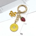 Détail du porte-clés tournesol et nid d'abeille avec breloque fraise sur carte - Style Fraise Nid d'Abeille