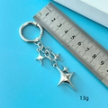 Gros plan de pendentifs étoile argentés sur porte-clés avec règle pour référence - Style Boucle Ronde Étoile Argent