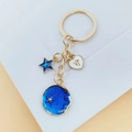 Porte-clés doré avec étoile à paillettes bleues et pendentif cœur blanc V - Capricorne