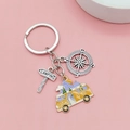 Outdoor camping keychain with yellow camper van, compass, and metal camping sign charms - Keychain Style