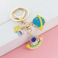 Detailed close-up of astronaut keychain with planet, star and moon charms in gold finish - Astronaut Moon Planet Style (LQ-0283#)