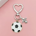 Détail d'un porte-clés de football avec fermoir en cœur et pendentif décoratif sport - Boucle Cœur Football Doré