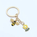 Porte-clés doré avec charms abeille émaillée et fleur jaune sur fond blanc - Design Abeille et Fleur