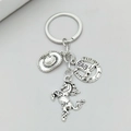 Detailed macro view of vintage silver cowboy hat, horseshoe, and horse charms on keychain - Antique Silver
