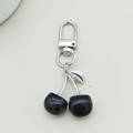 Detail shot of cherry-shaped keychain with shiny black globes and silver metal clip - D-Clasp / Silver Leaf Black