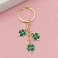 Détail du porte-clés trèfle vert porte-bonheur avec métal doré sur fond rose poudré - Vert
