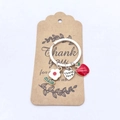 Détail du pendentif cœur Thank You, pomme rouge et fleur sur un porte-clés argenté - Pack Petite Carte Fleur Blanche