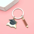 Detail of graduation enamel keychain with black cap book and red pencil charms - Graduation Cap and Books Style