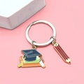 Graduation keychain featuring blue doctoral cap, colorful books and a red pencil pendant - Doctoral Hat & Diploma Style