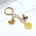 Détail d'un porte-clés abeille et marguerite avec des ailes en strass étincelantes - Style Nid d'Abeille Abeille Strass