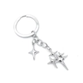 Porte-clés en métal argenté avec pendentifs étoiles superposés sur un fond blanc neutre - Trois Étoiles Polies (C)