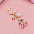 Pink resin cherry keychain with gold ring, green leaves and small white pearl pendant - Transparent Pink Round Cherry