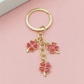 Porte-clés doré avec trois trèfles à quatre feuilles rouges et grand anneau - Rouge