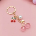 Pink and red cherry keychain with white pearl and gold metal ring on pink background - Transparent Pink Square Cherry