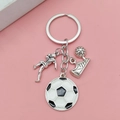 Porte-clés de football argenté avec pendentif joueur et ballon sur un fond rose doux - Style Football Argent Antique