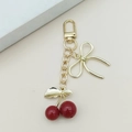 Porte-clés cerise élégant avec nœud doré et perles rouges pour sacs à main femmes - Cerise rouge plaquée UV (Fermoir en D) / Rouge Vif