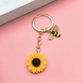 Porte-clés tournesol doré avec charm abeille et pétales jaunes sur fond rose - Style Porte-clés Or Tournesol Abeille