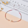 Detalle de pulsera ajustable de cuentas Miyuki con perla blanca central en cordón lila - Rosa Púrpura Oro (QQ431)