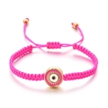 Détail du bracelet tressé rose Evil Eye avec breloque à bord doré et cordon ajustable - Rose rouge