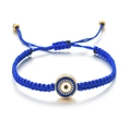Détail du bracelet tressé œil bleu avec nœud coulissant et perles dorées fines - Bleu foncé