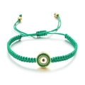 Détail du bracelet en cordon tressé vert avec un pendentif œil maléfique doré - Vert