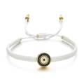 Détail d'un bracelet en corde tressée blanche avec pendentif œil maléfique doré chic - Blanc